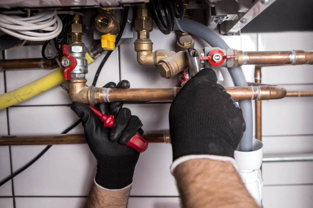 plumber turning connections of a boiler